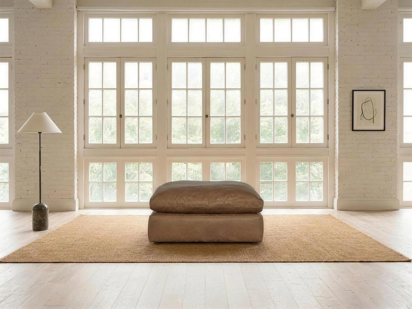 Emilia Leather Ottoman in caramel top-grain leather, styled in a living room