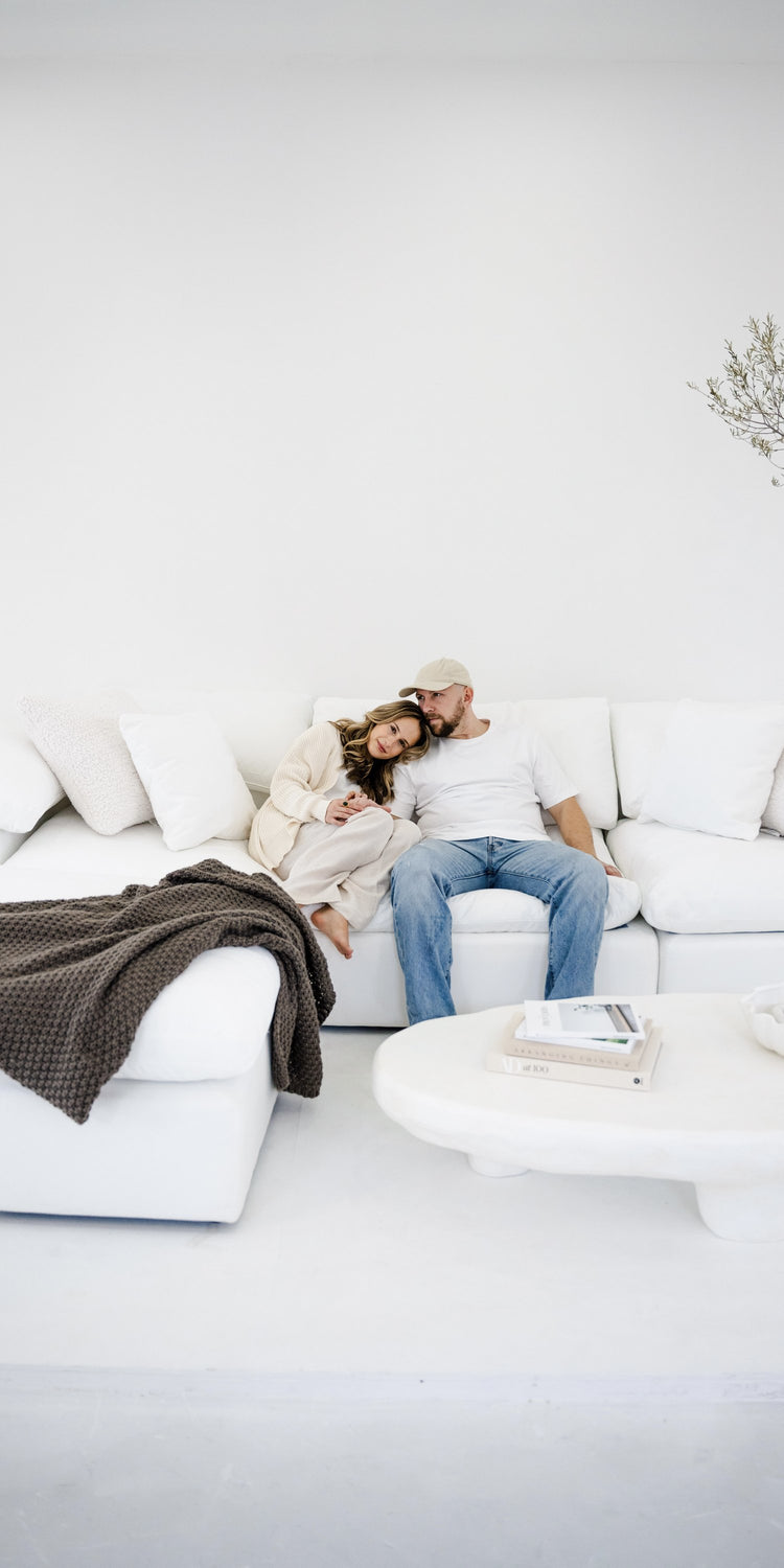 The family owners of Fin's Furniture relaxing together on a white cloud sectional sofa
